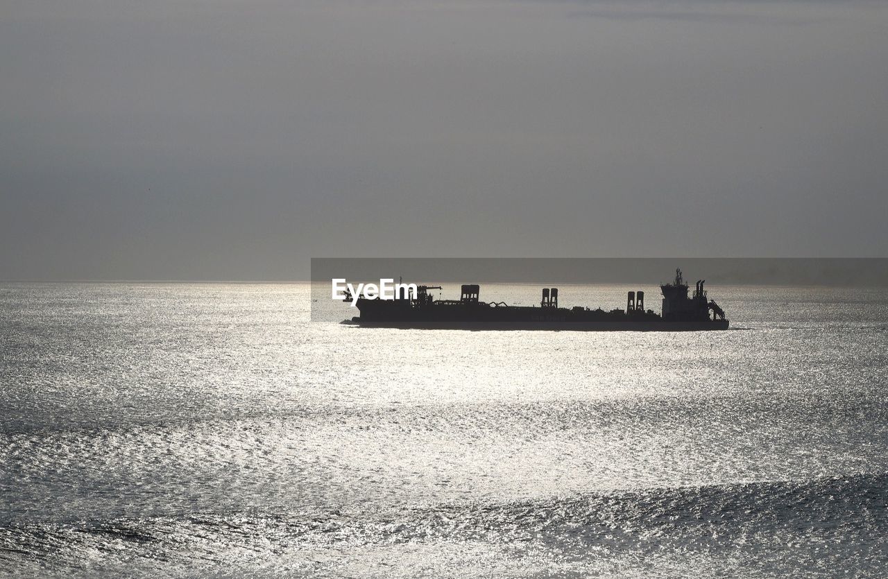 Ship sailing in sea against sky