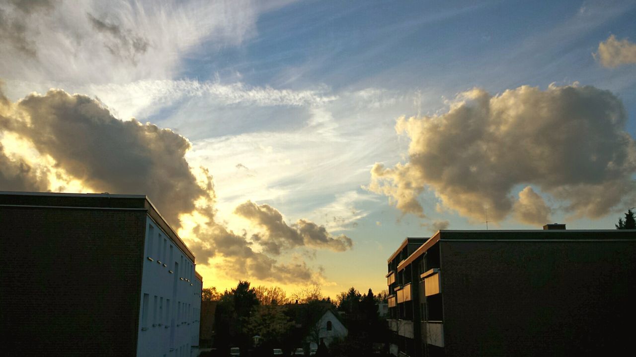 LOW ANGLE VIEW OF HOUSES AGAINST CLOUDY SKY