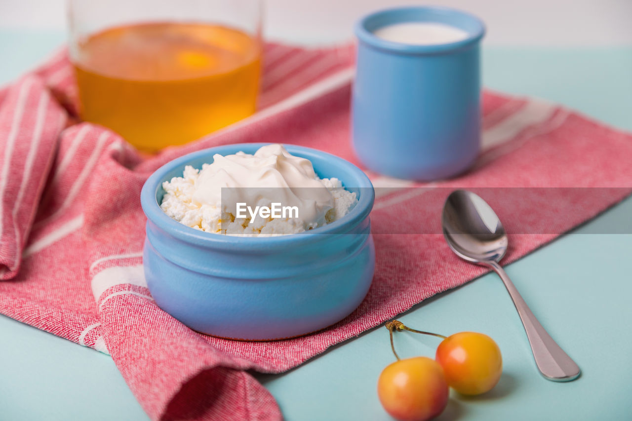 Cottage cheese in a blue bowl with sour cream and honey.