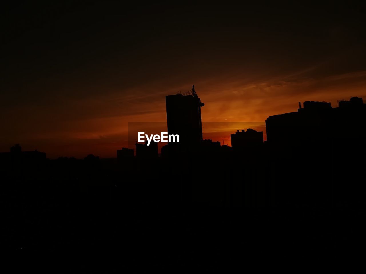 Silhouette buildings against sky during sunset