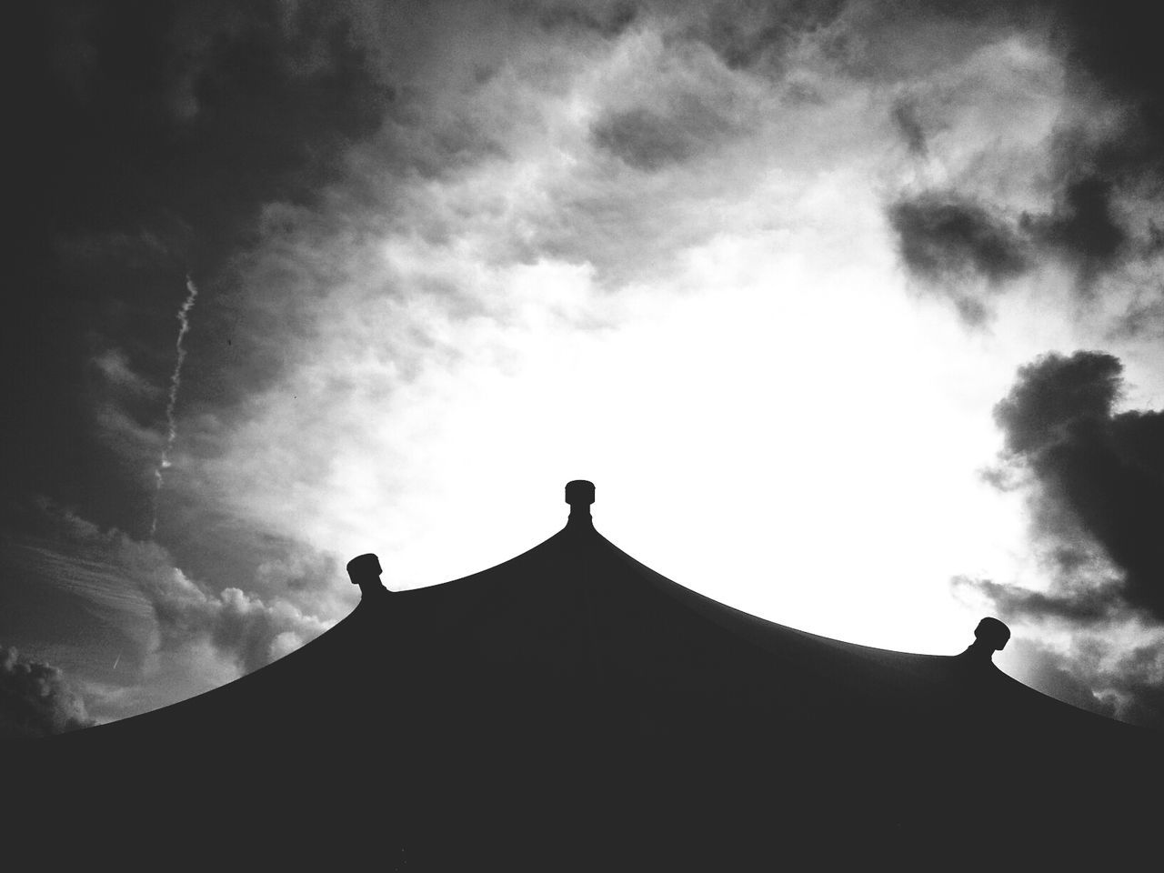 Silhouette house against cloudy sky