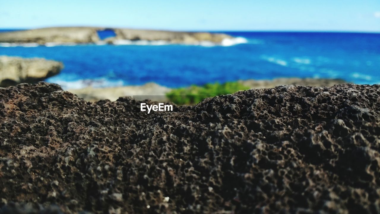 Close-up of pebbles on beach against sky