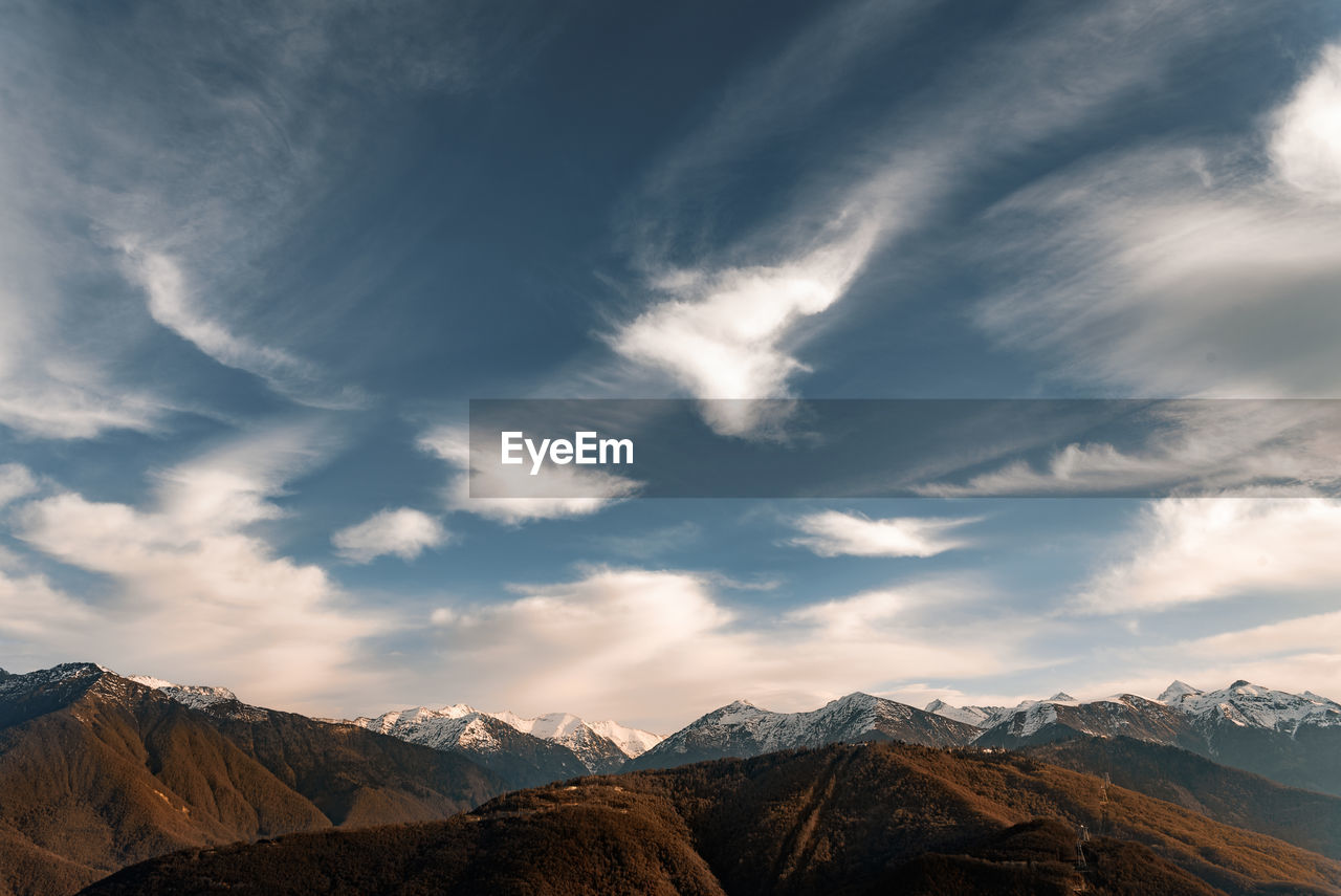 SCENIC VIEW OF MOUNTAINS AGAINST CLOUDY SKY