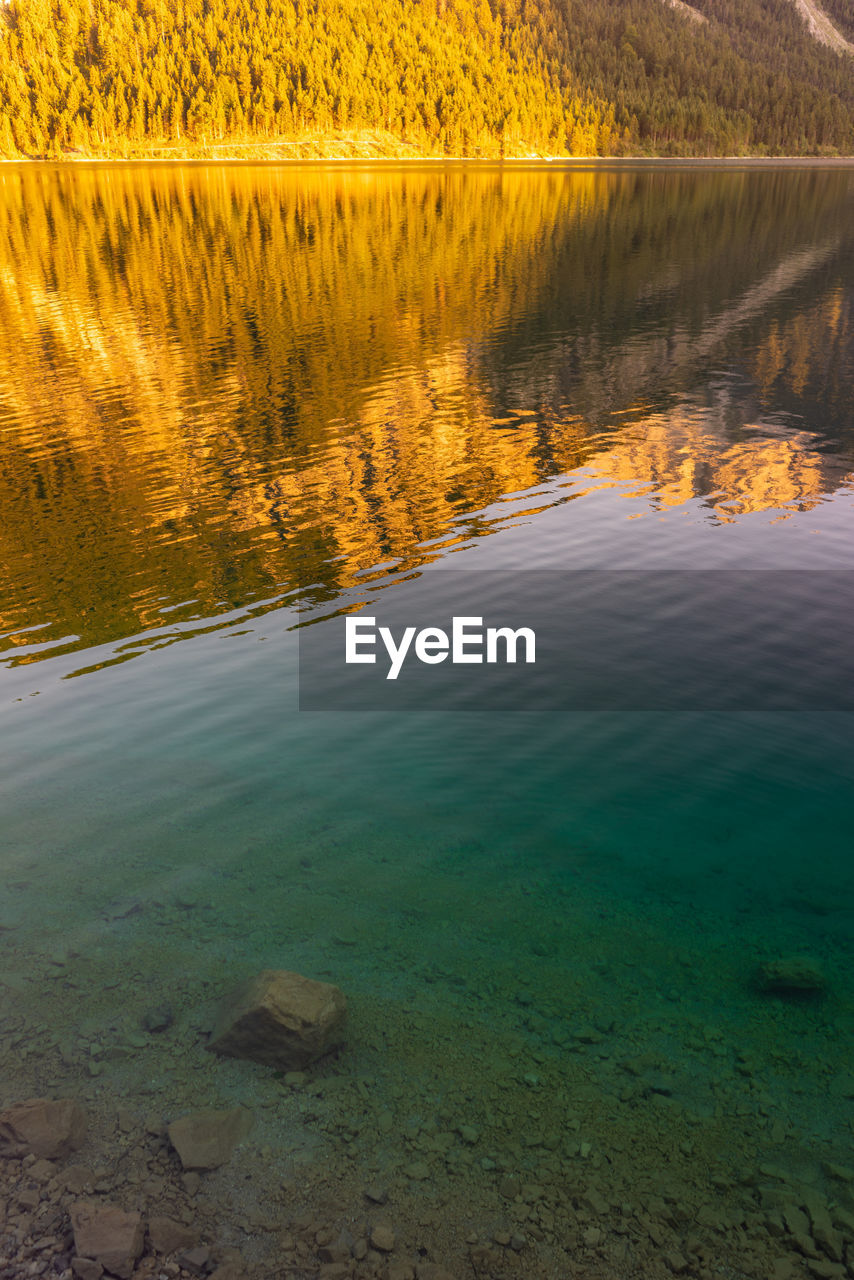 Scenic view of lake against sky at sunset