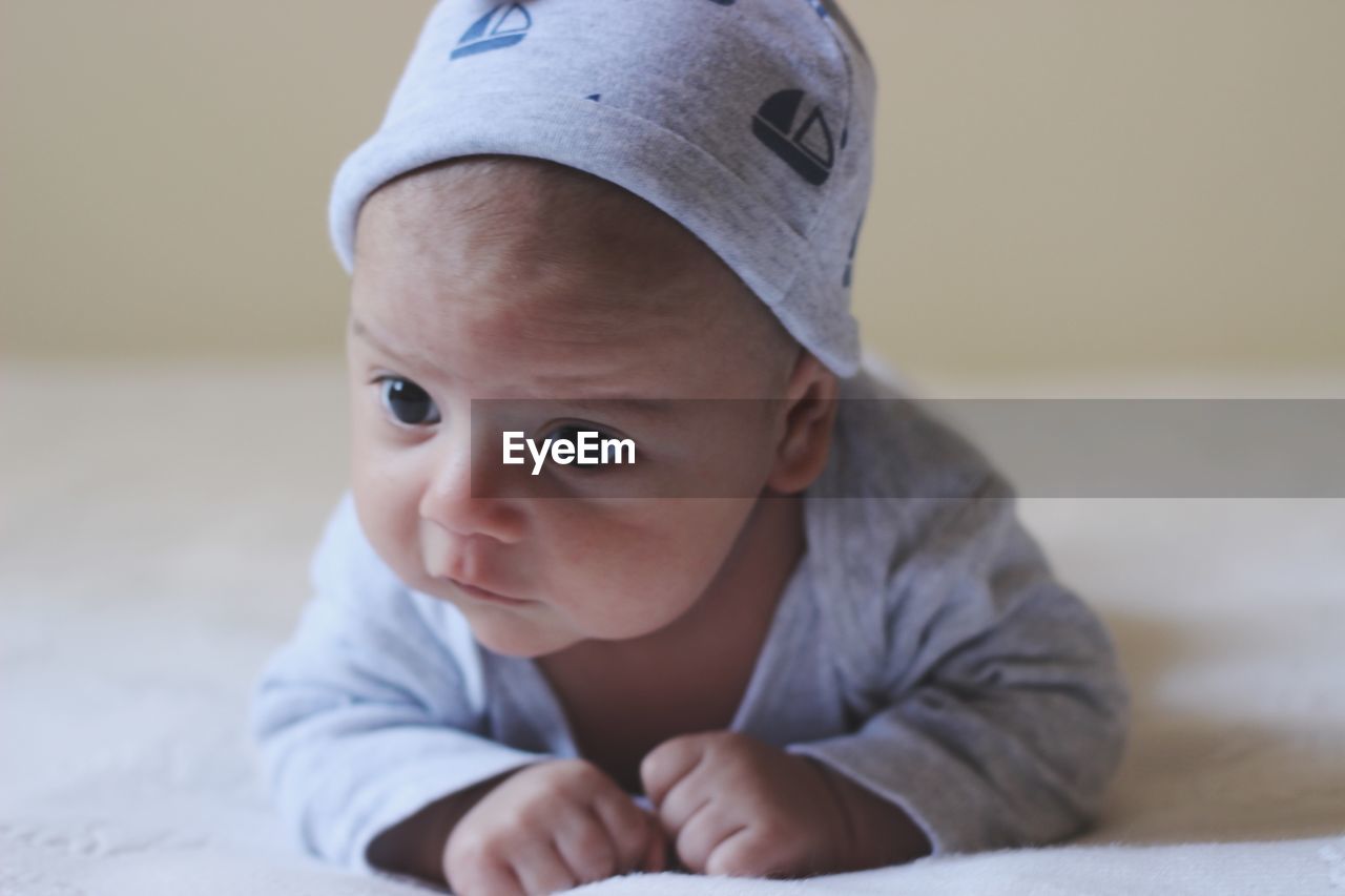 Cute baby boy lying on bed at home