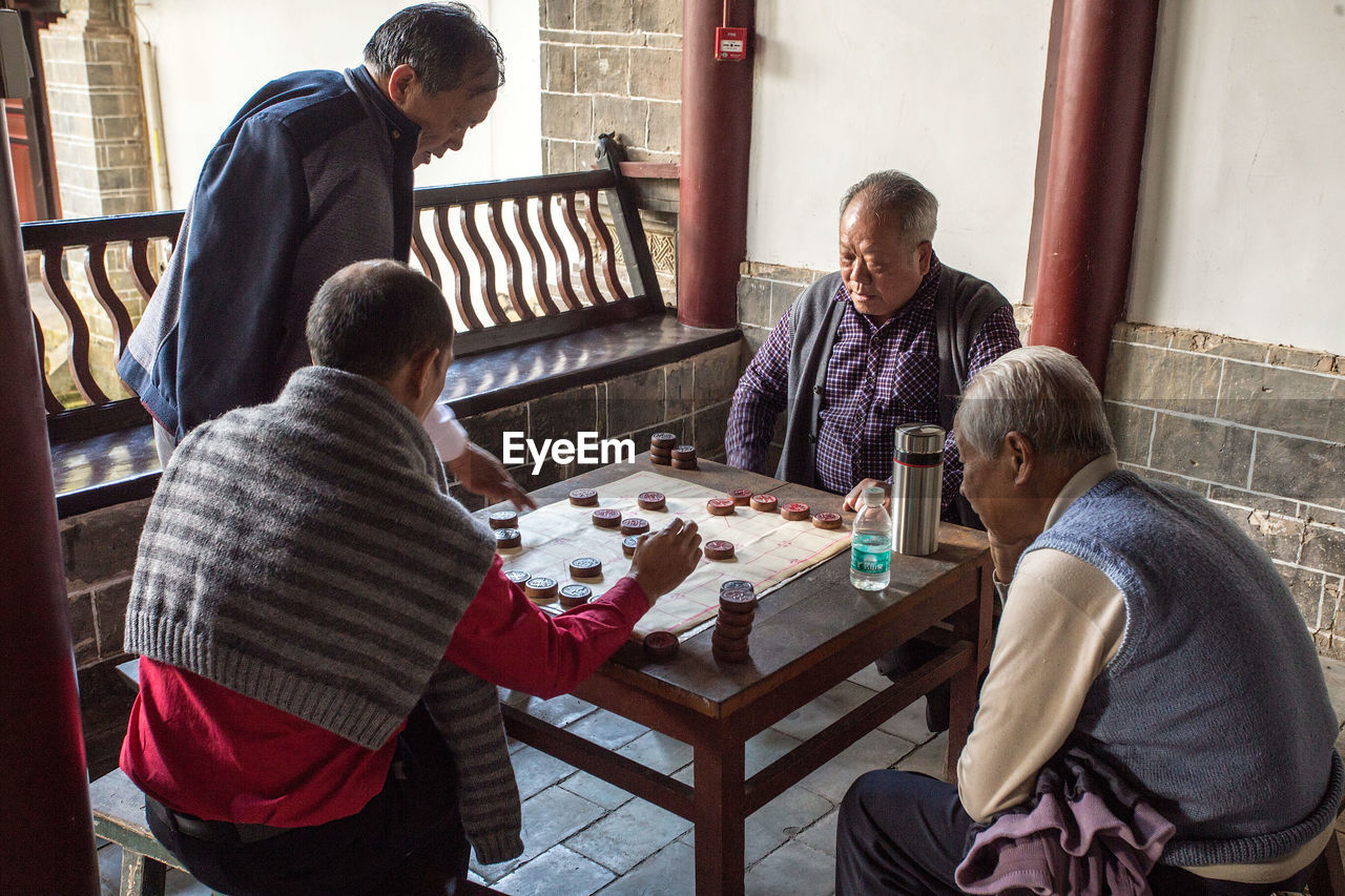 REAR VIEW OF PEOPLE AT TABLE