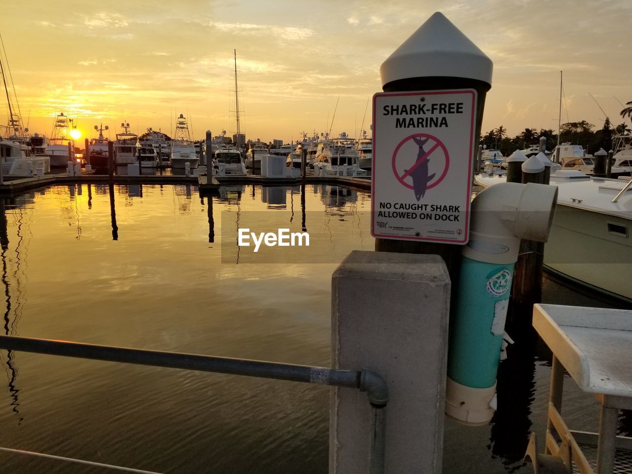 CLOSE-UP OF COMMERCIAL DOCK BY RIVER AGAINST SKY