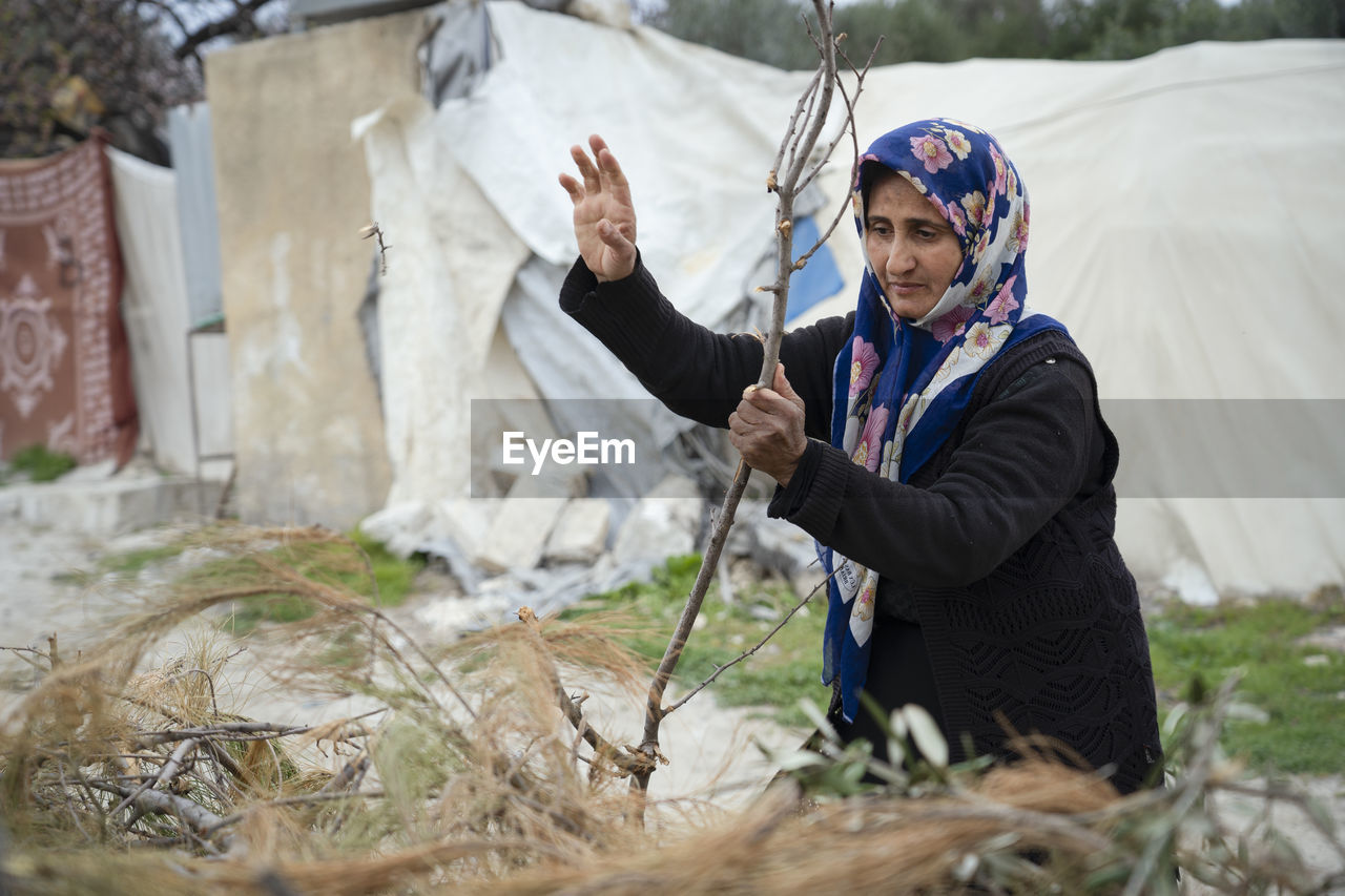 A refugee woman and her daughter cook with wood.