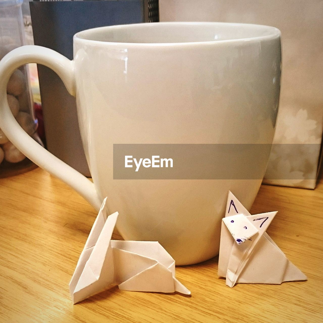 Paper birds and coffee cup on table