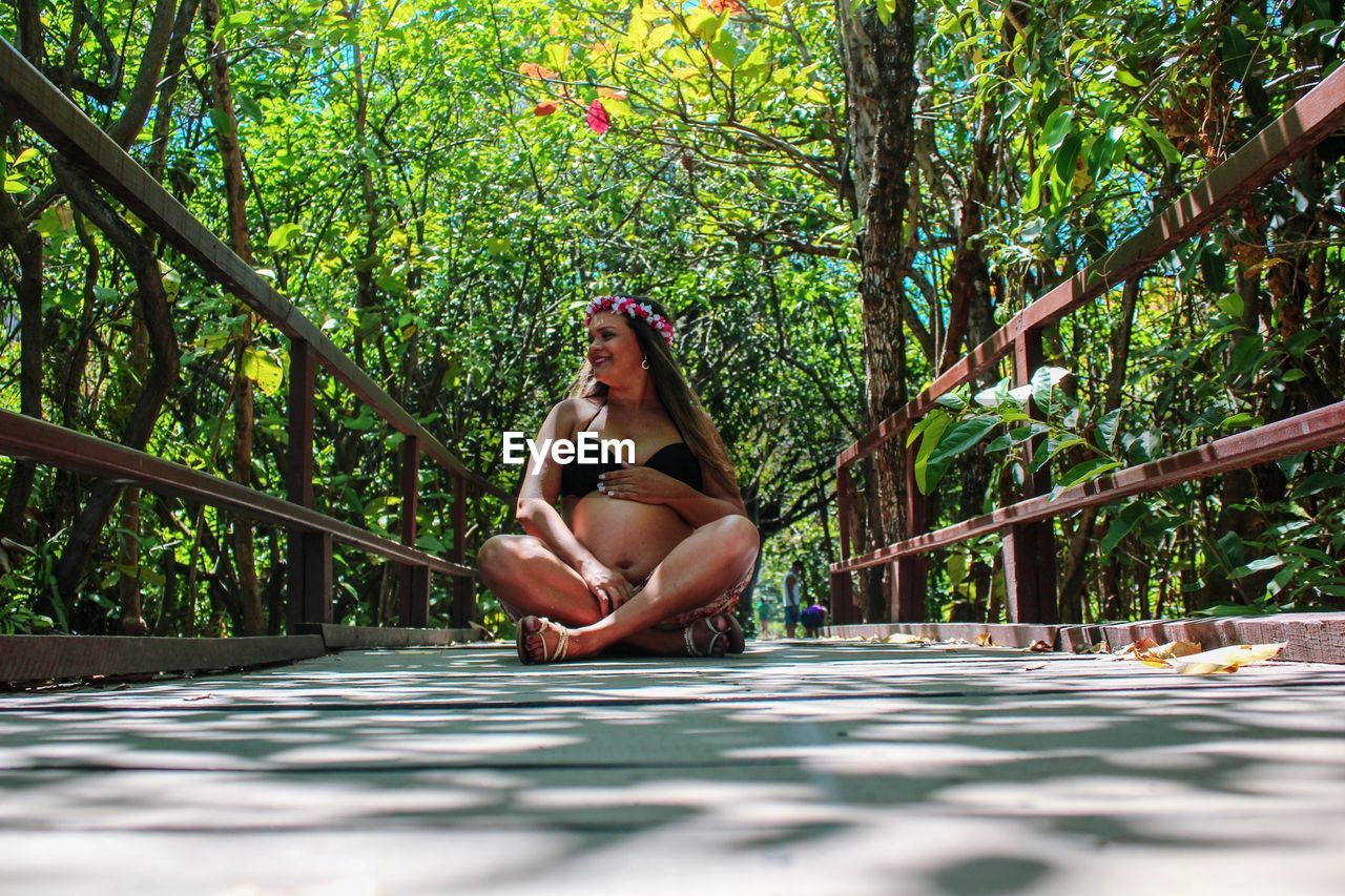 WOMAN SITTING ON PLANT