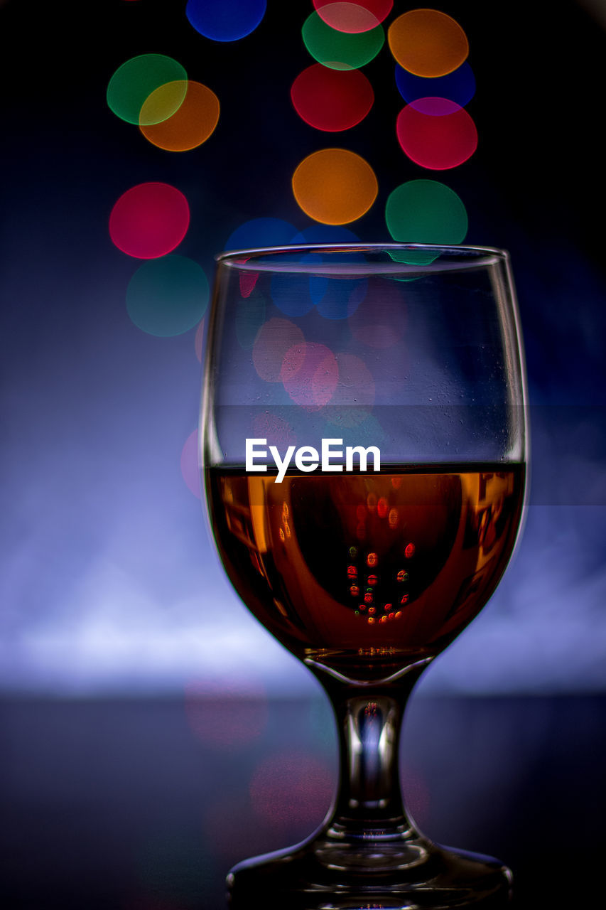 Close-up of wineglass on table against black background