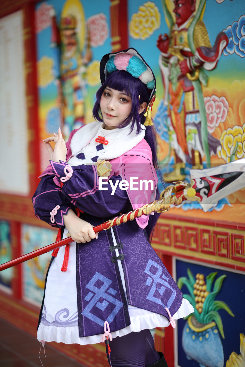 portrait of cute girl standing in traditional clothing