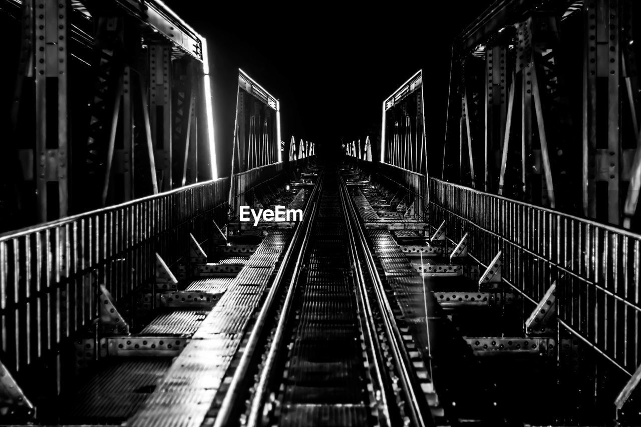 Railway bridge against sky at night