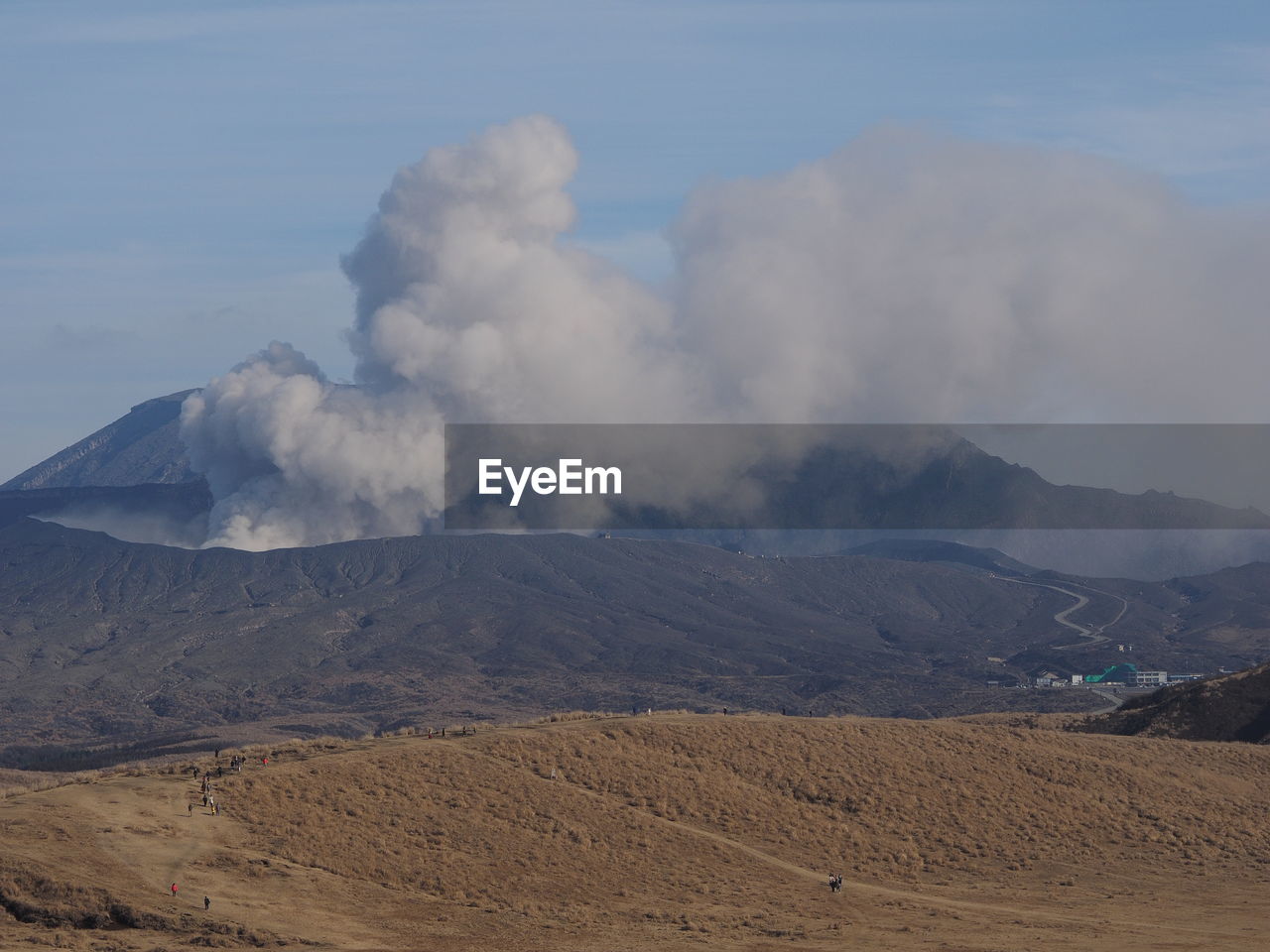 SMOKE EMITTING FROM VOLCANIC LANDSCAPE AGAINST SKY