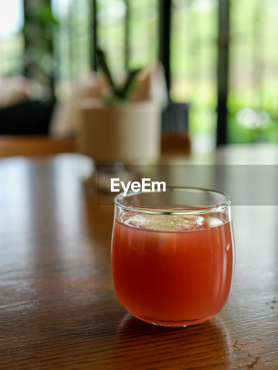 CLOSE-UP OF DRINK ON GLASS TABLE