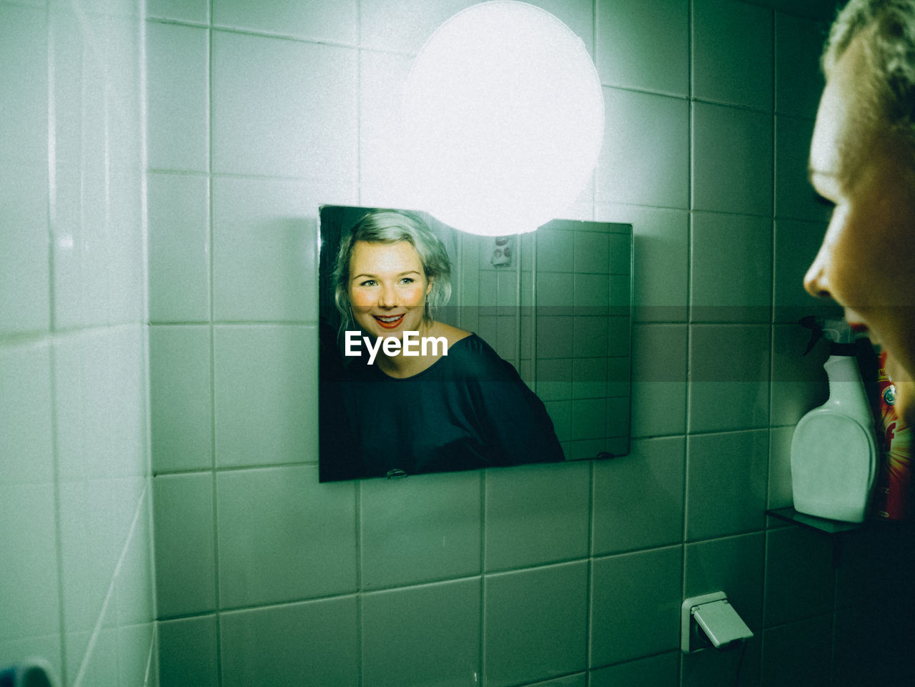 Reflection of beautiful woman on mirror in bathroom
