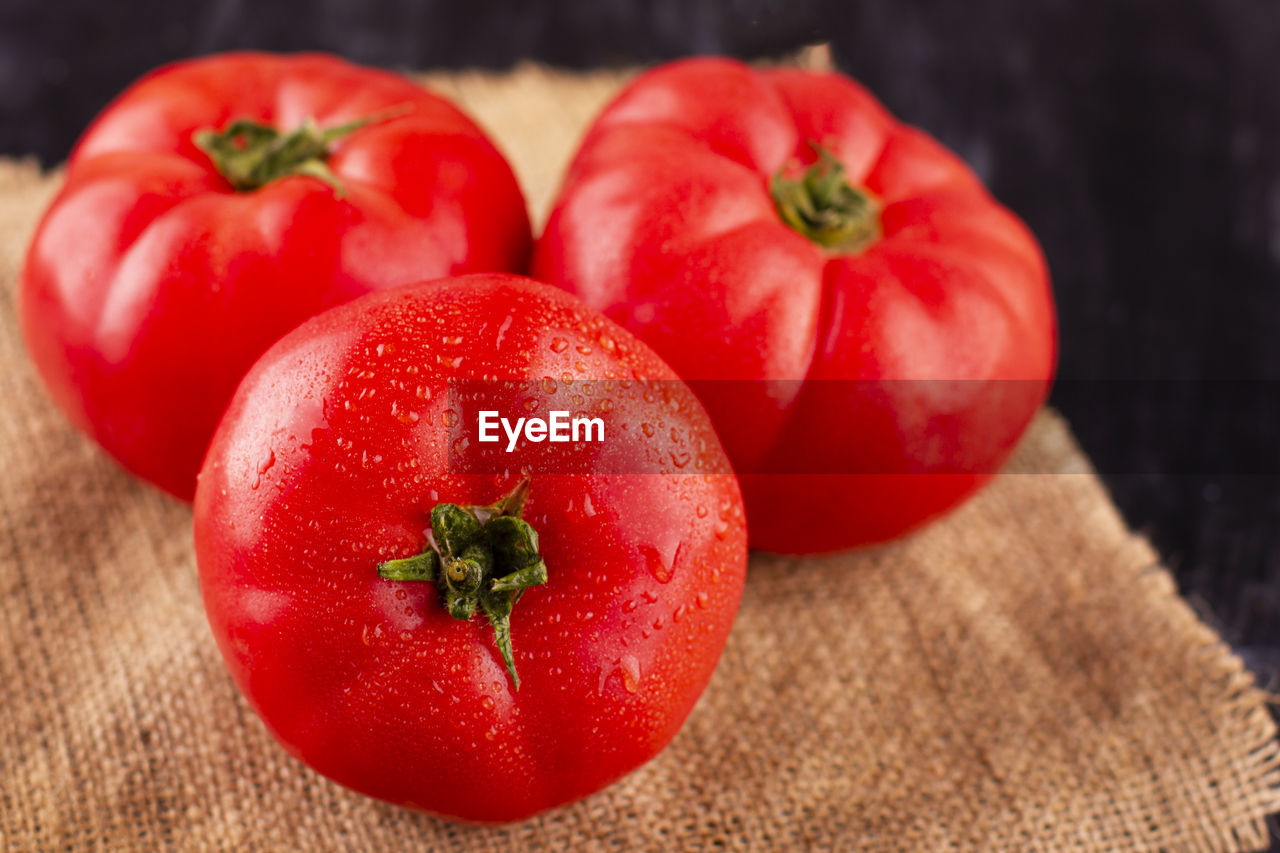 Large pink tomatoes with droplets of water. fresh ripe vegetables on a wooden table