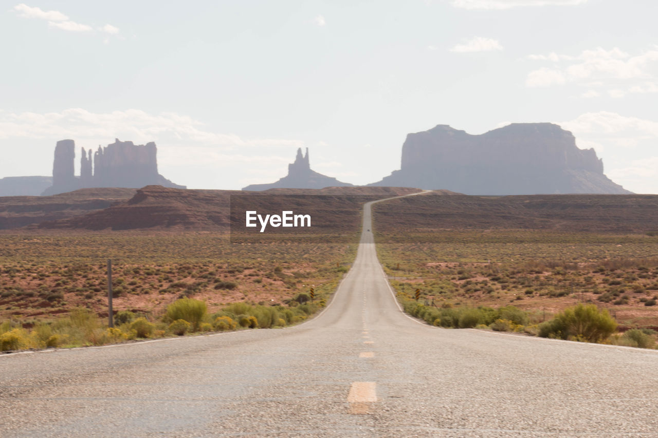 Diminishing perspective of empty road against sky during sunny day