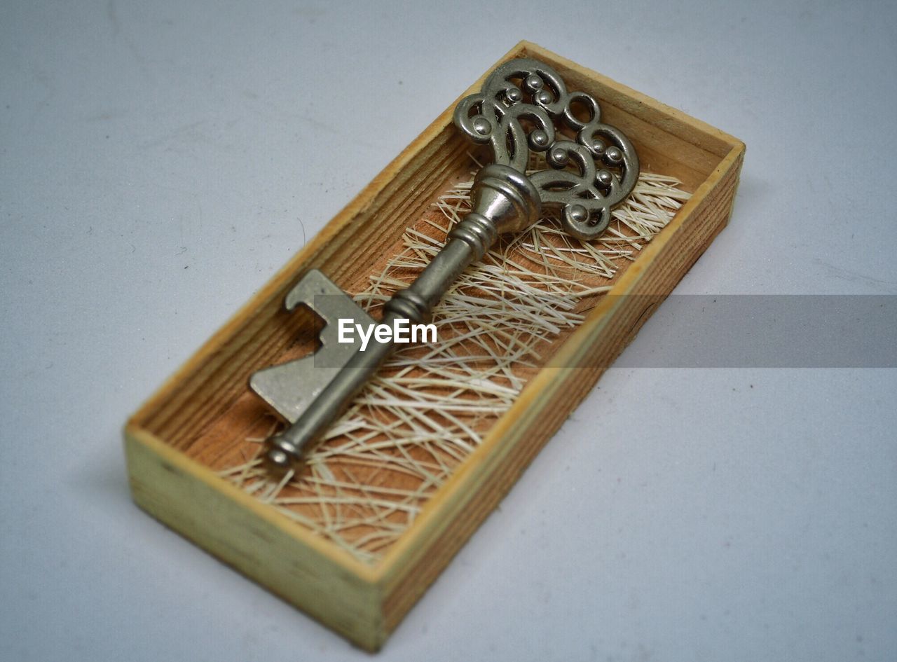 Close-up of key in wooden box on table