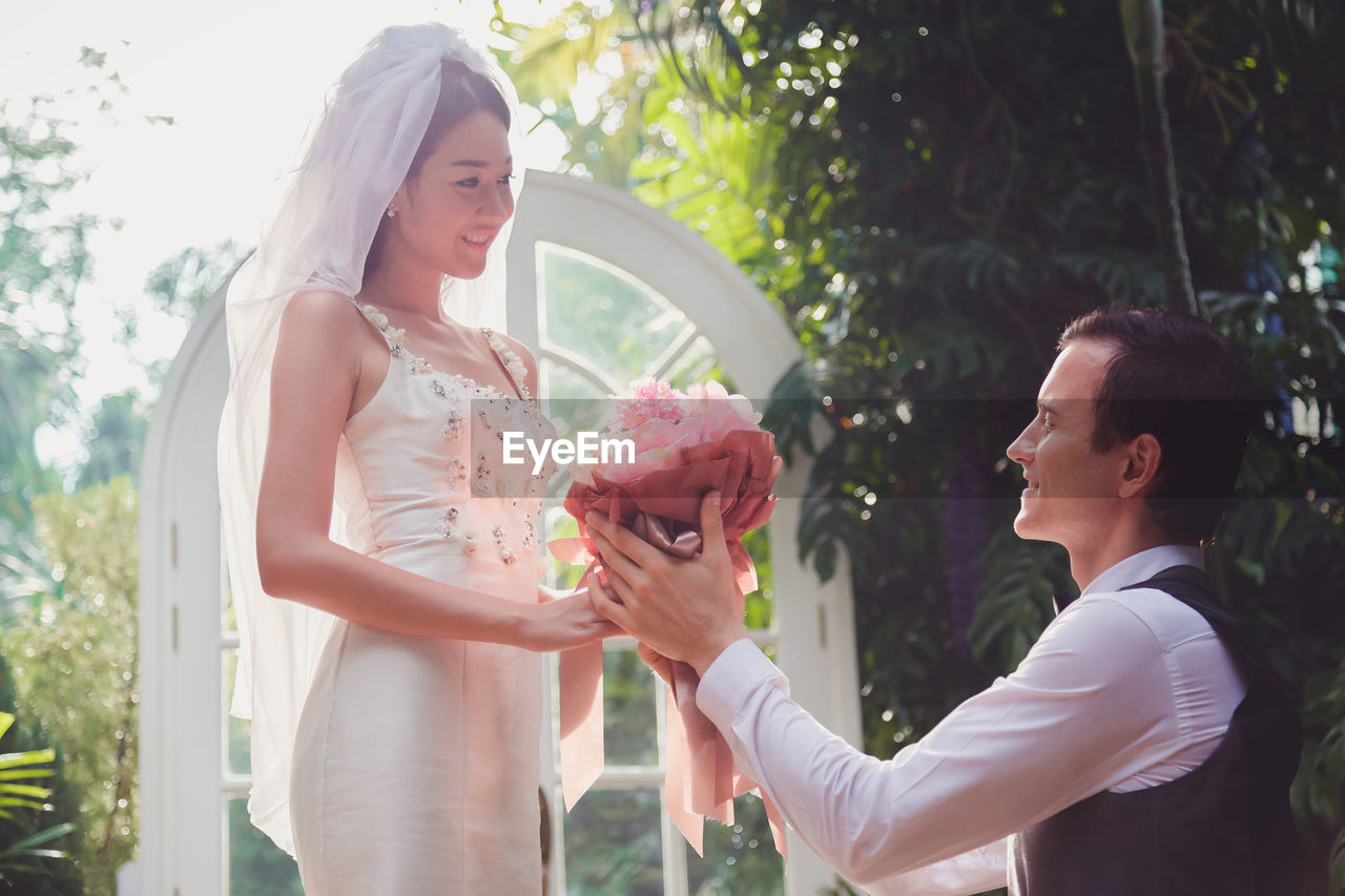 Groom giving flowers to bride at wedding