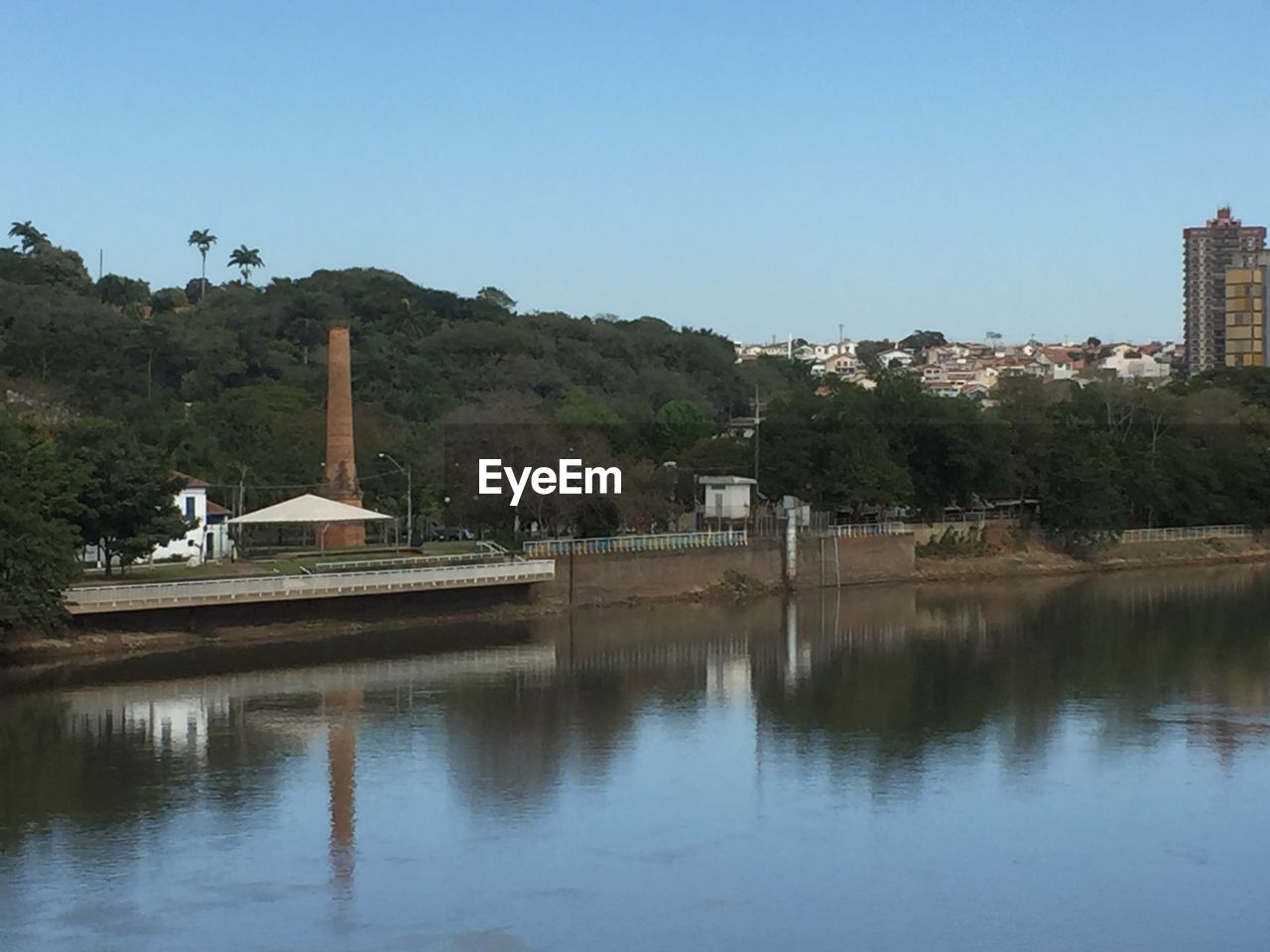 REFLECTION OF TREES ON WATER AGAINST CLEAR SKY