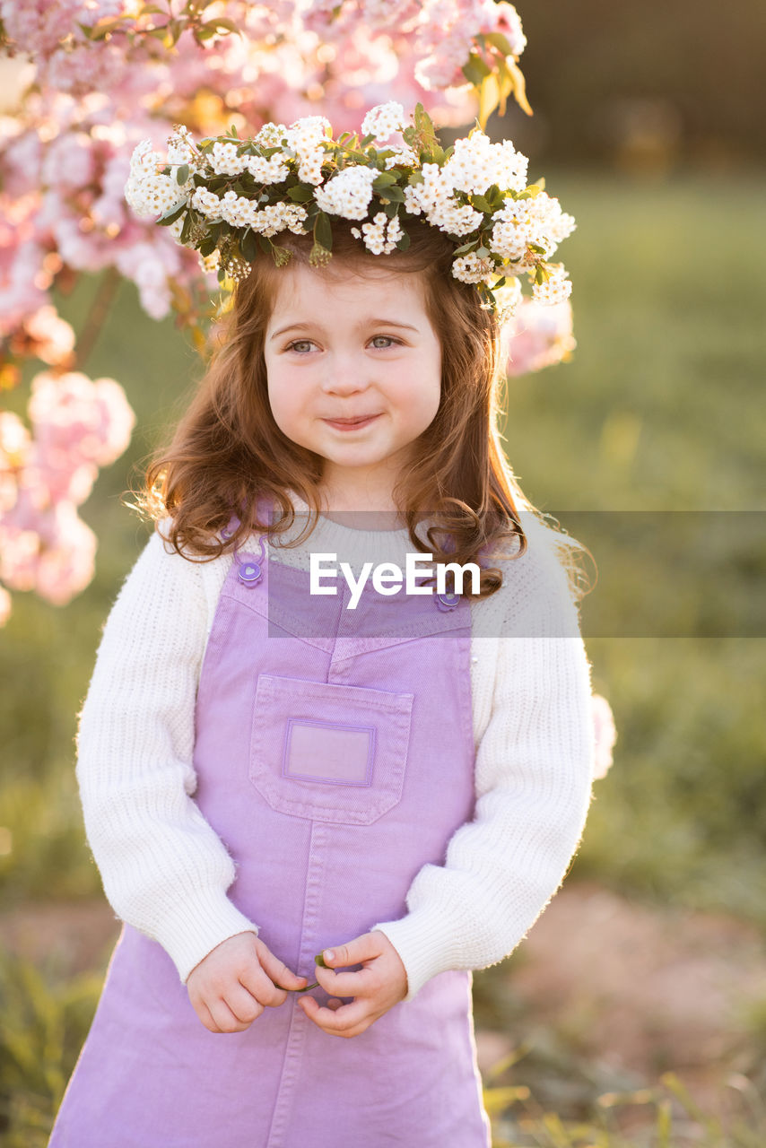 Cute girl wearing wreath looking away