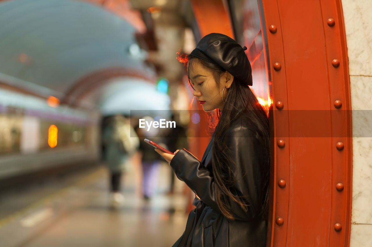 Trendy japanese girl suffer from smartphone and social media addiction miss train at subway platform