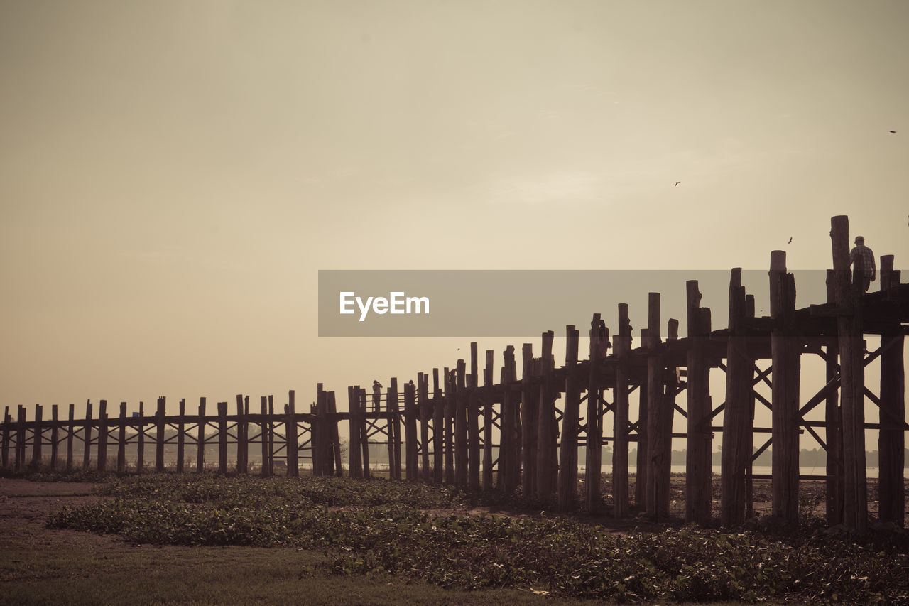 Wooden gate on beach against sky