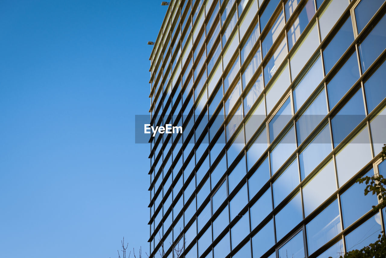 Glass building facade with sky reflection