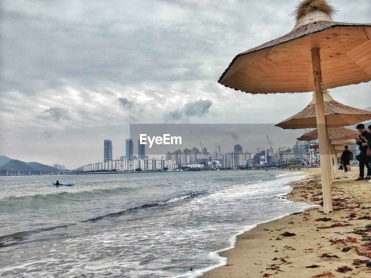 PEOPLE ON BEACH AGAINST SKY