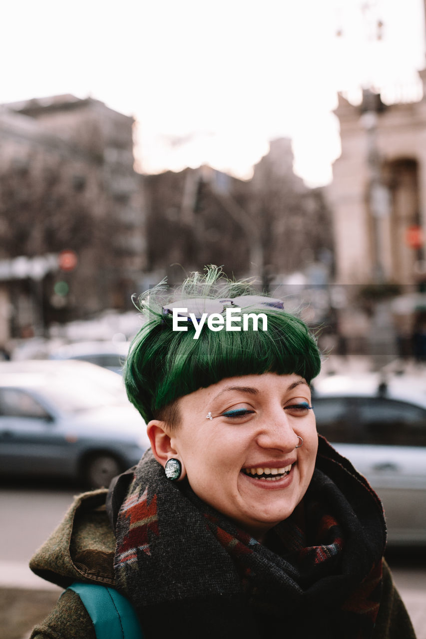 Portrait of happy hipster walking on street in city during winter