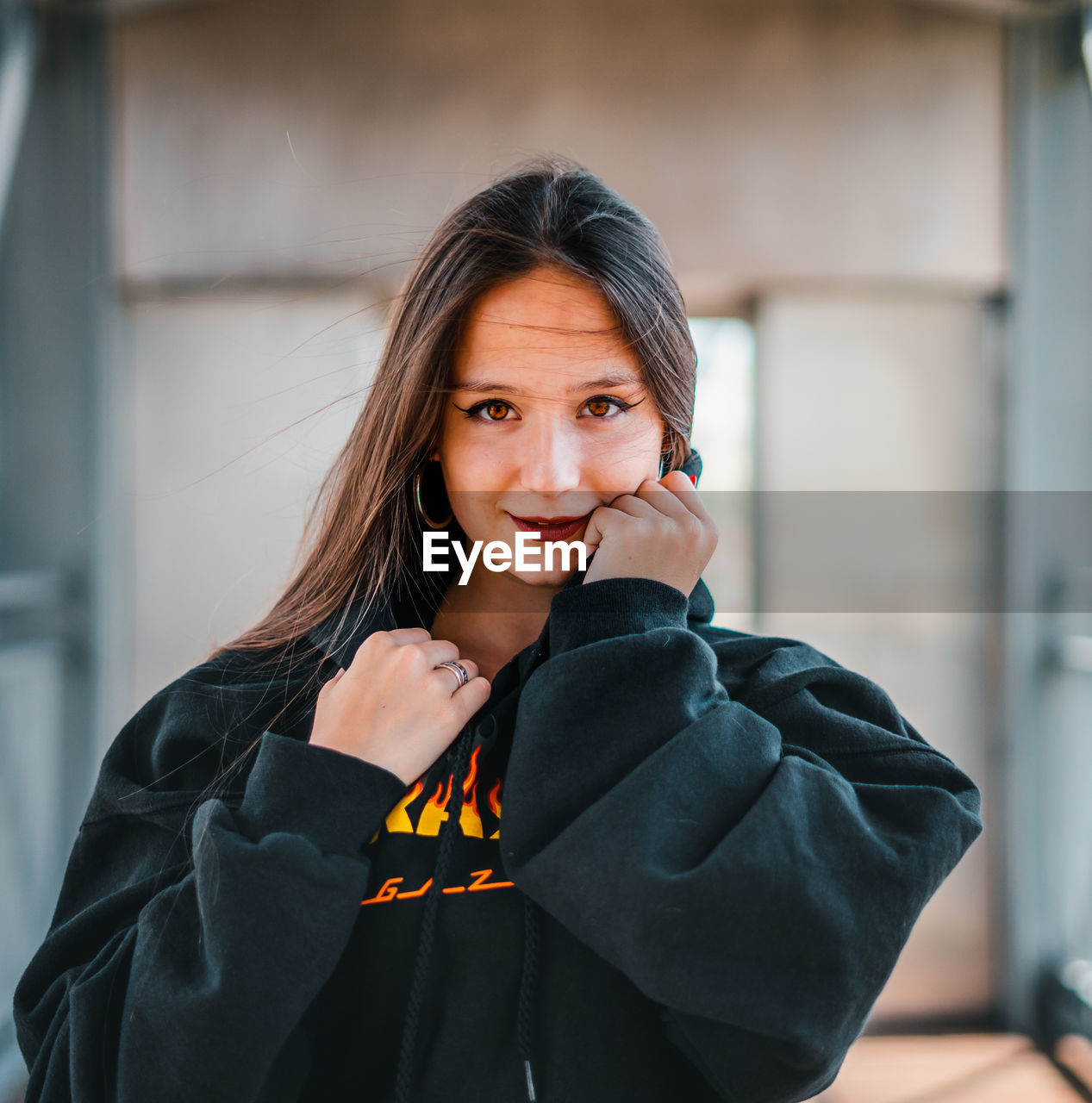 Portrait of smiling woman standing against wall