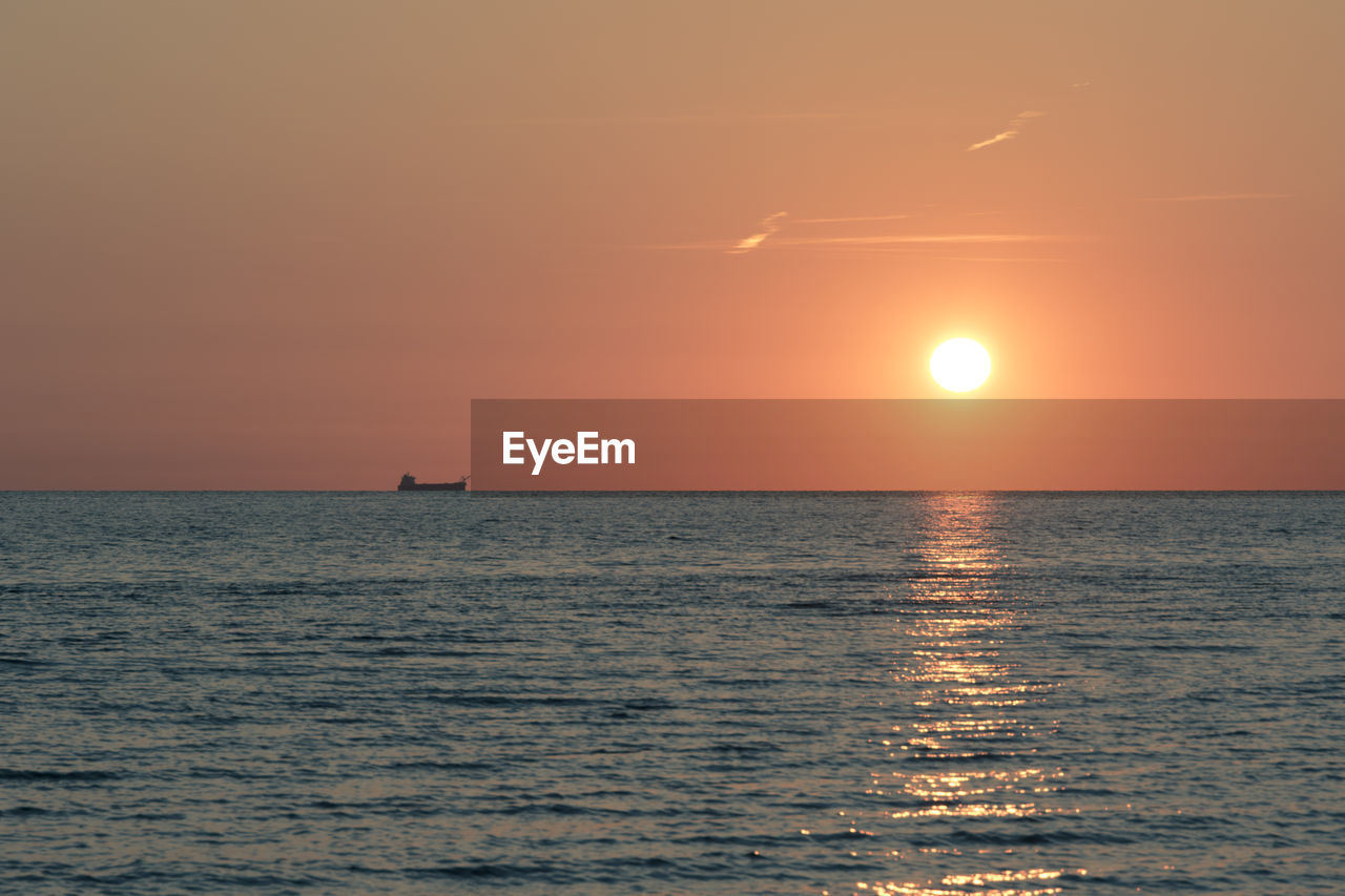 Scenic view of sea against orange sky