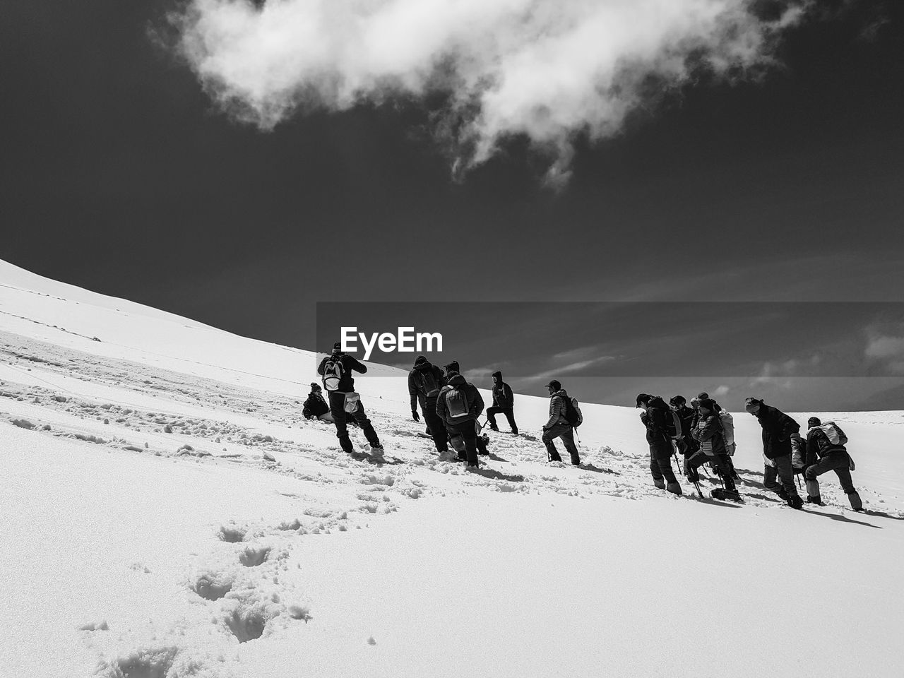 People on snow covered land against sky