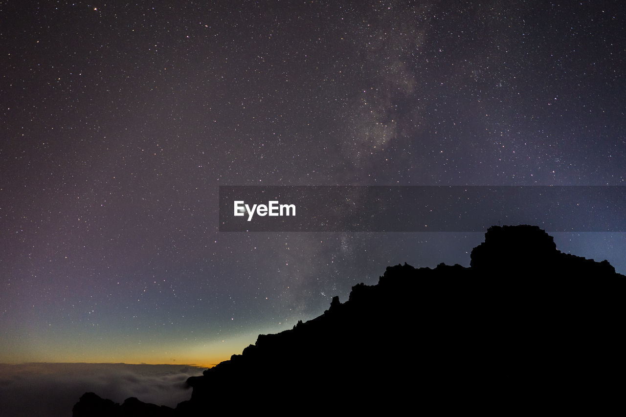 Scenic view of mountains against sky at night