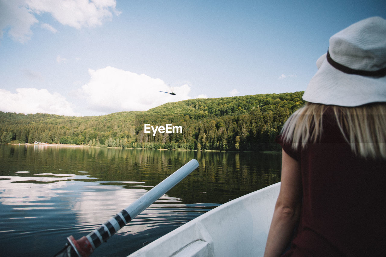 Rear view of woman in boat on lake