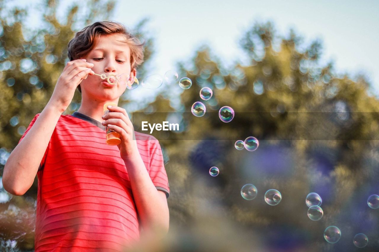 FULL LENGTH OF WOMAN WITH BUBBLES IN MID-AIR