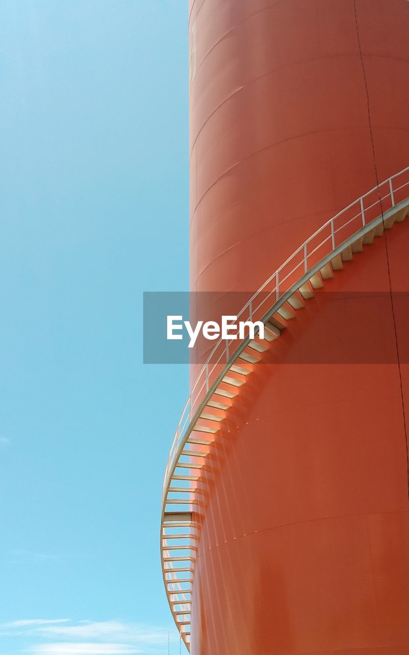 Low angle view of spiral staircase against clear blue sky