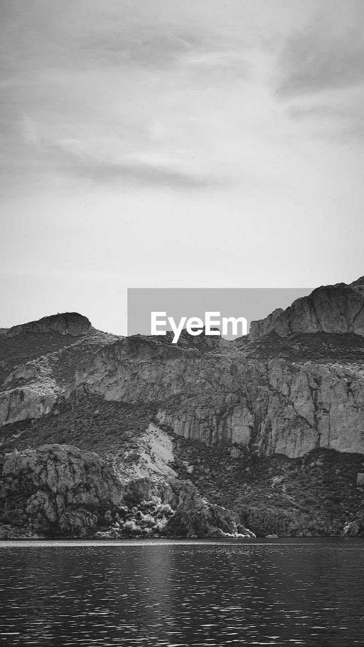 Scenic view of sea and mountains against sky