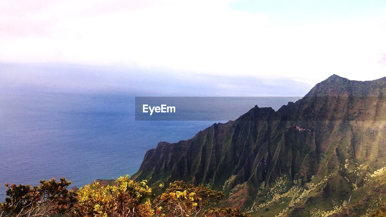 SCENIC VIEW OF SEA BY MOUNTAIN AGAINST SKY