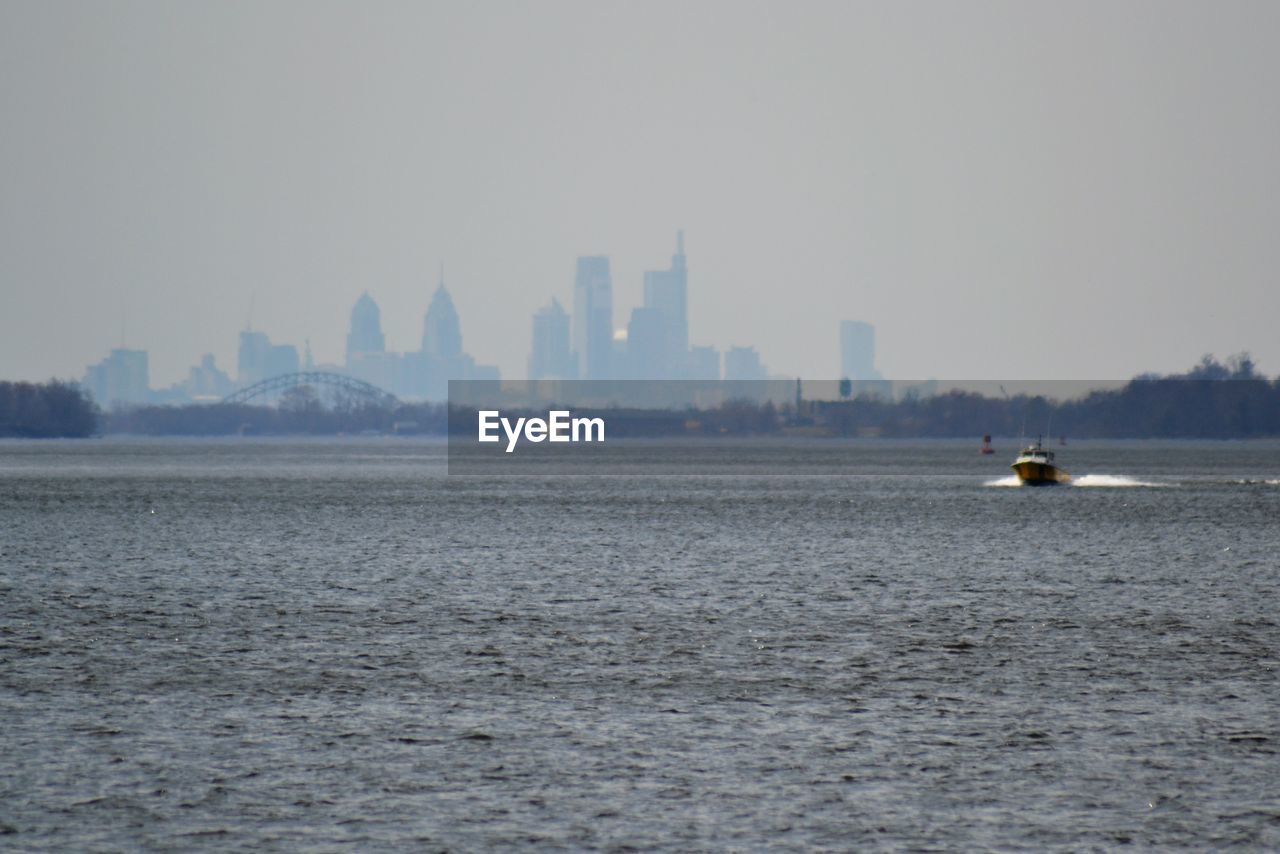 SCENIC VIEW OF SEA AGAINST BUILDINGS IN CITY