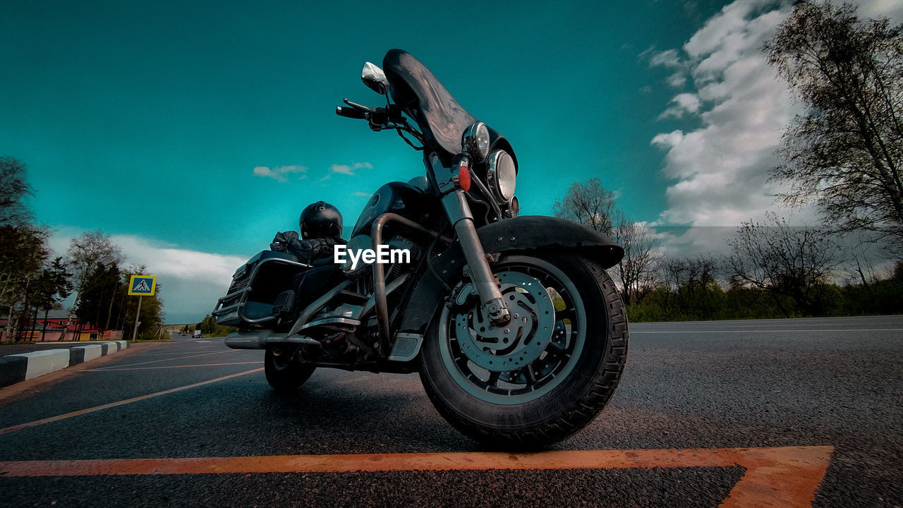 Motorcycle on road against sky in city