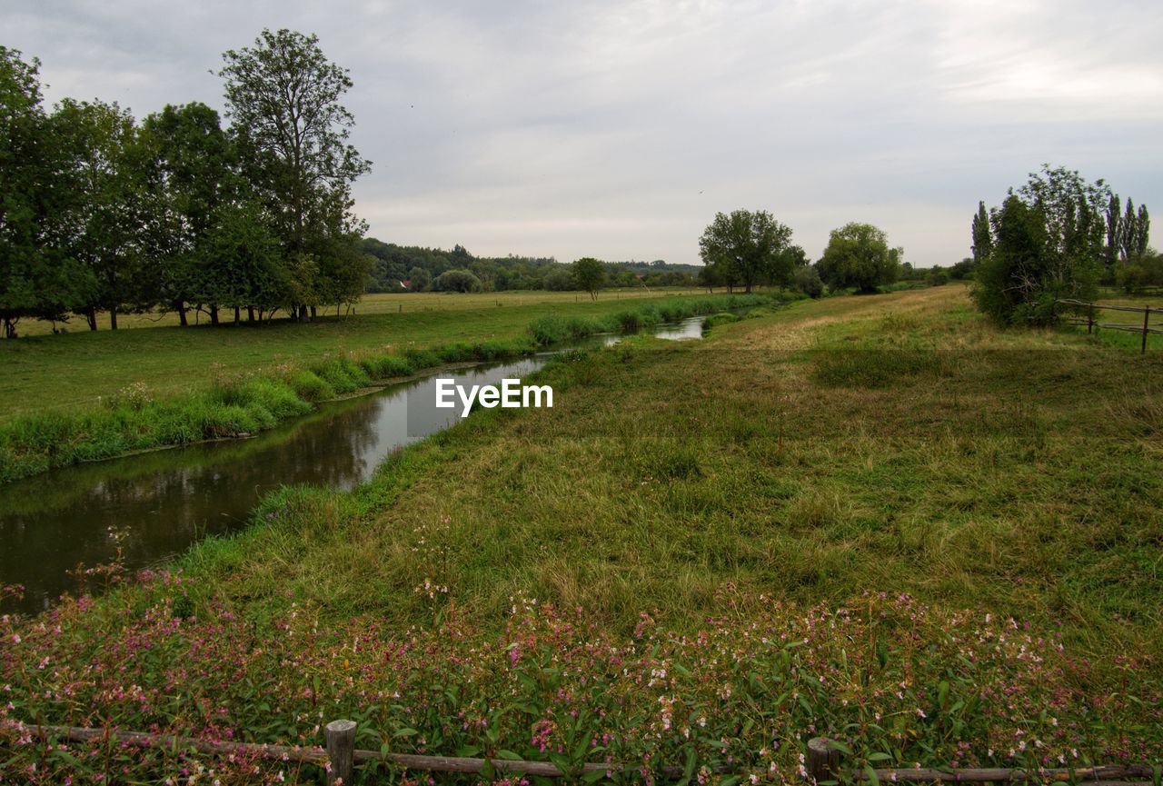 SCENIC VIEW OF CANAL AMIDST FIELD