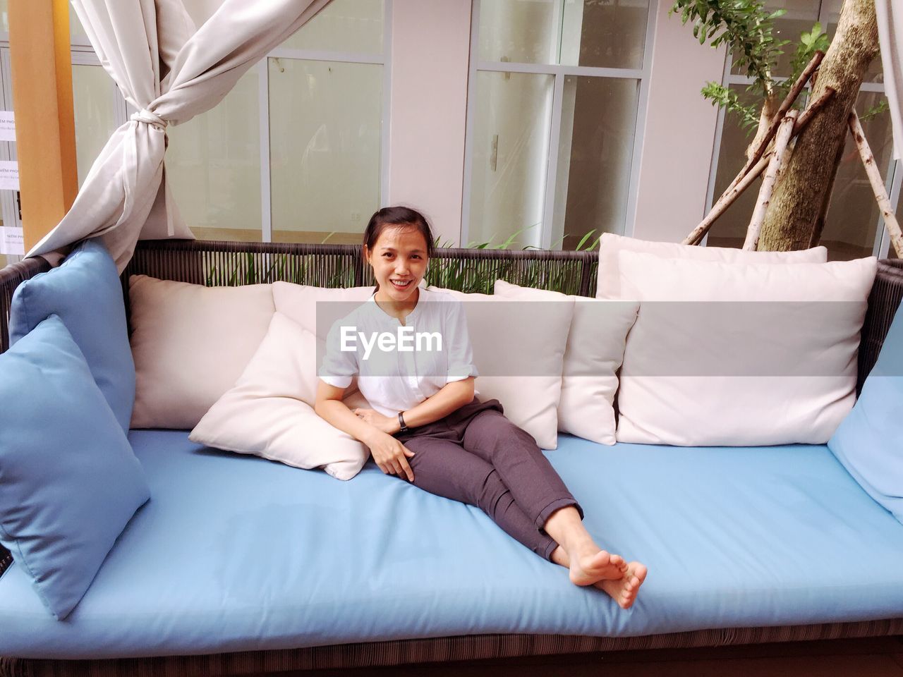 Portrait of smiling woman sitting on sofa at home