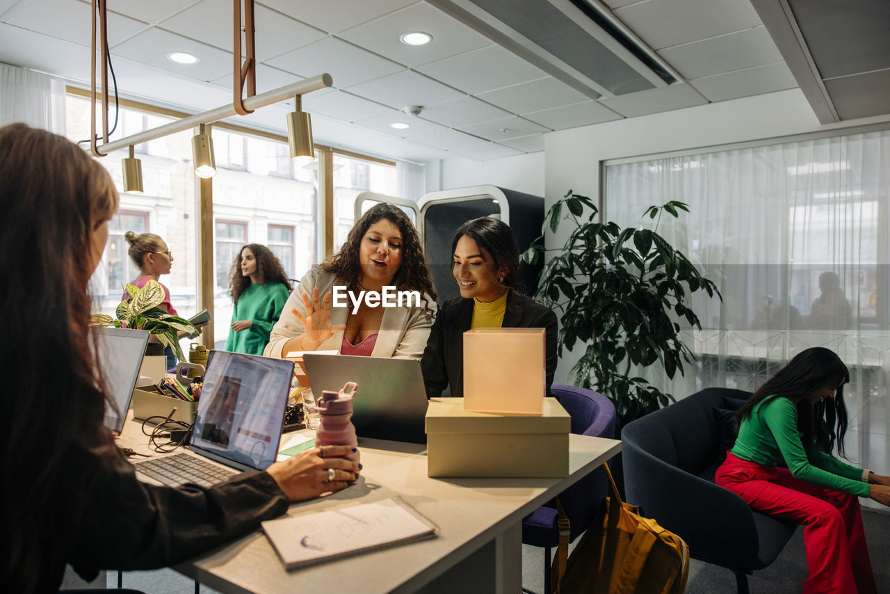 Multiracial female entrepreneurs discussing while working at office