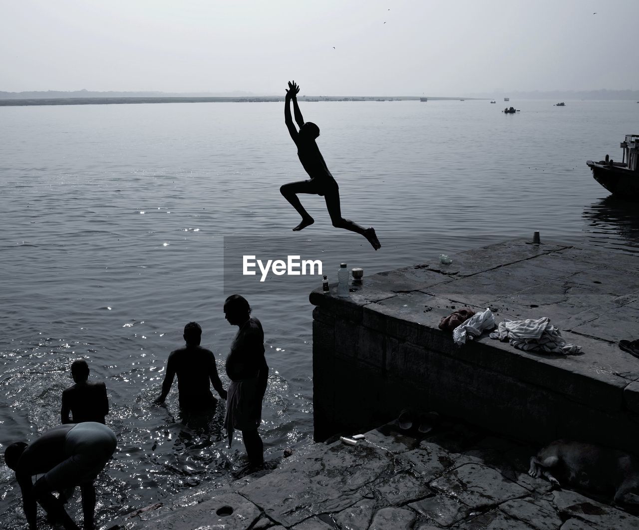 PEOPLE JUMPING ON BEACH AGAINST SEA