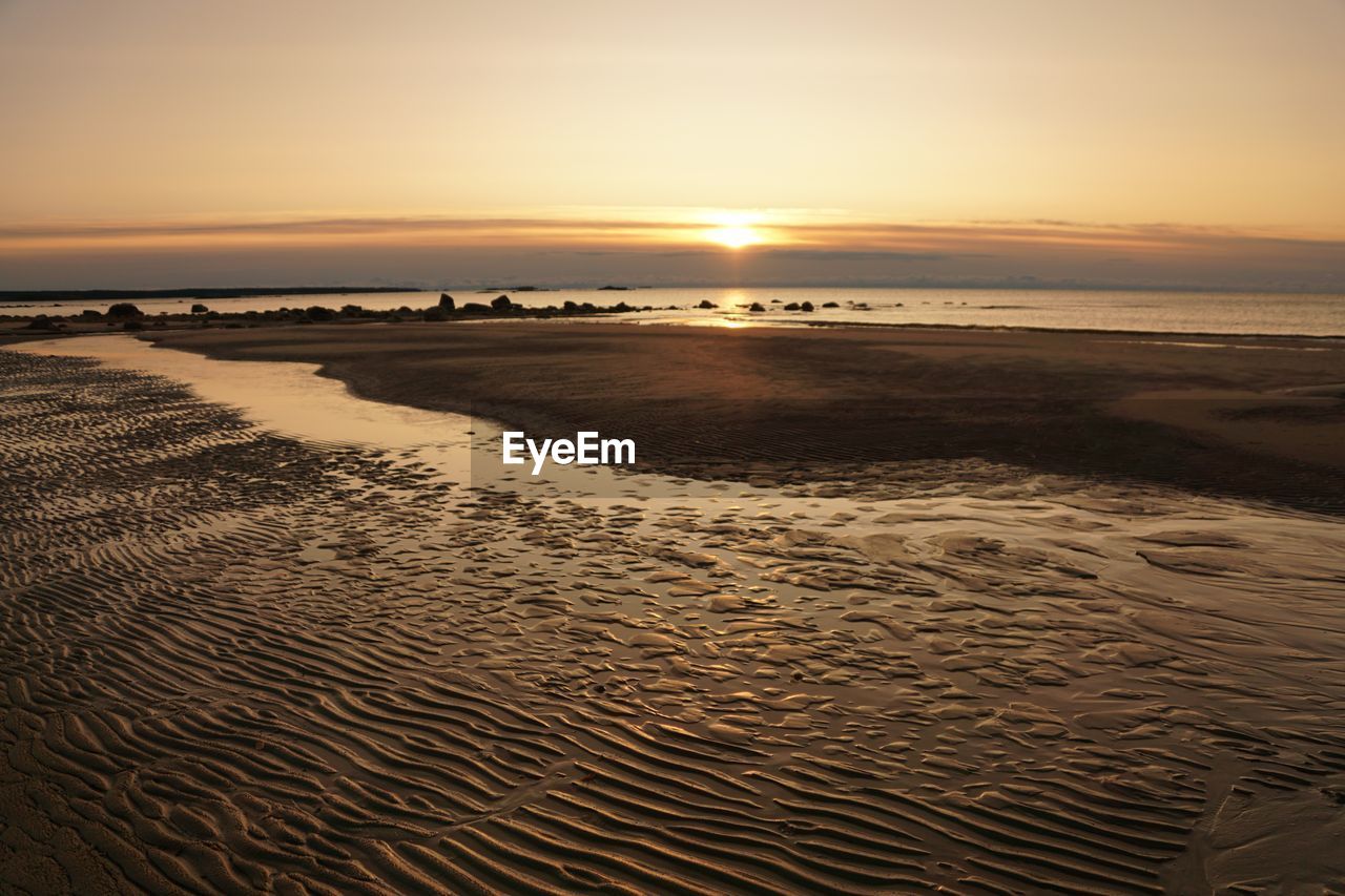 Scenic view of beach against sky during sunset