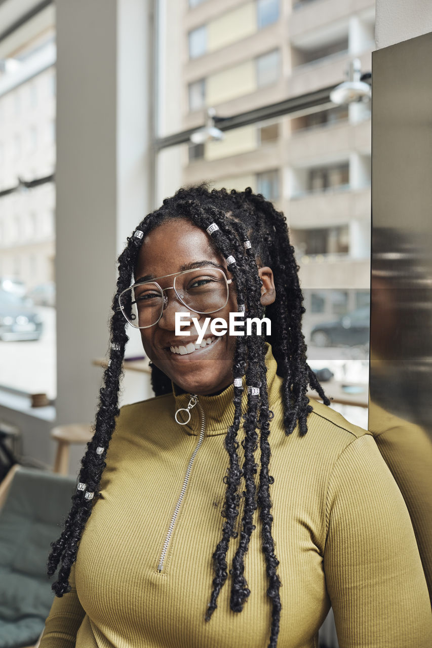 Portrait of happy businesswoman with locs at office