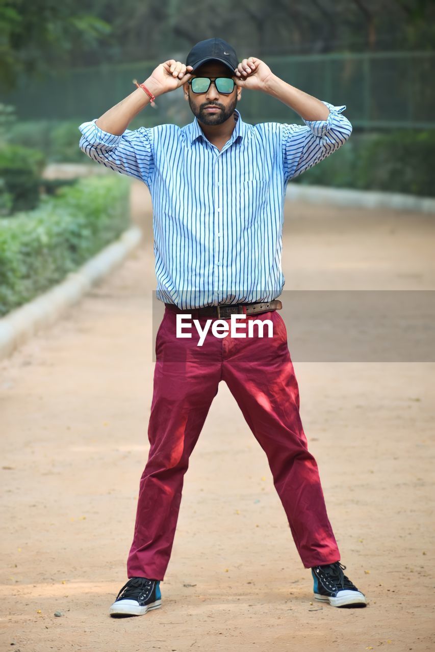 full length of young man walking on footpath