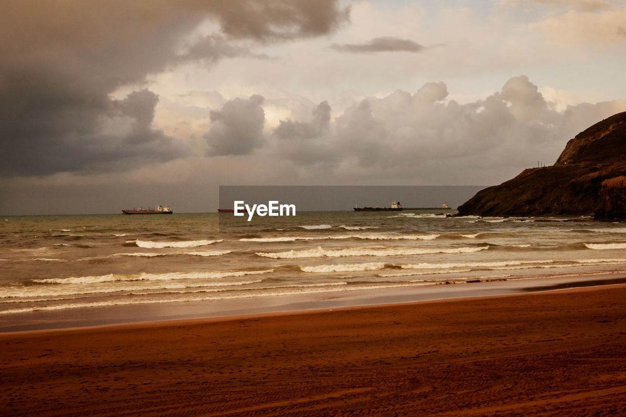 SCENIC VIEW OF BEACH AGAINST SKY DURING SUNSET